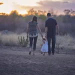 Happy couple walking daughter after stepparent adoption in Georgia.