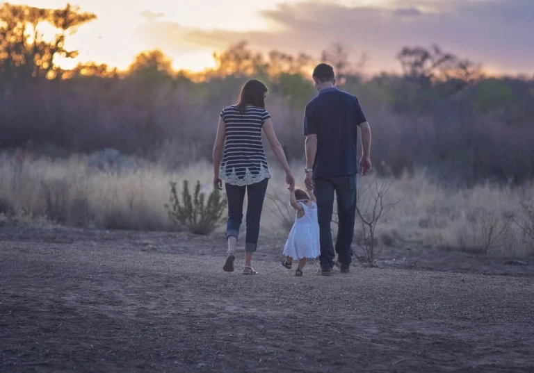 Happy couple walking daughter after stepparent adoption in Georgia.