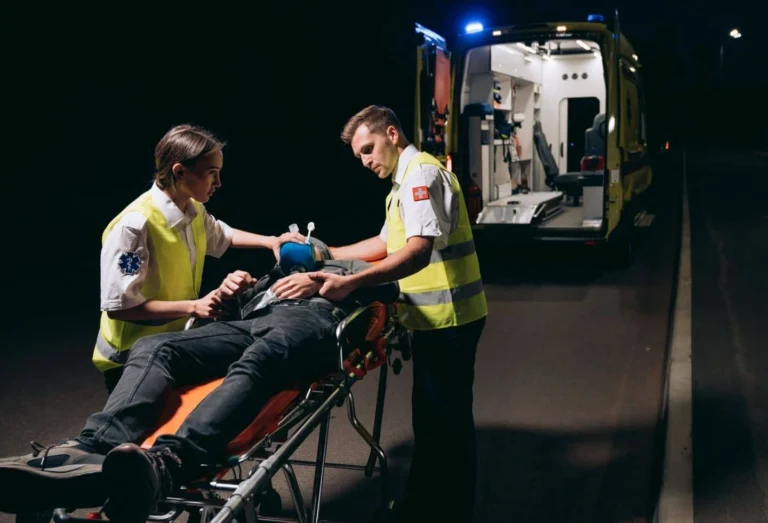Paramedics attending to an injured person to load onto an ambulance.